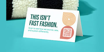 Tent cards with QR code in front of fashion product on blue background