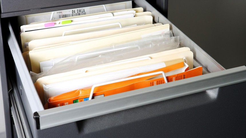 Open Filing Cabinet drawer with messy files inside.