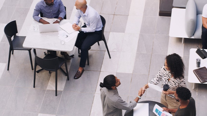 People sitting on tables conversing amongst each other at an event