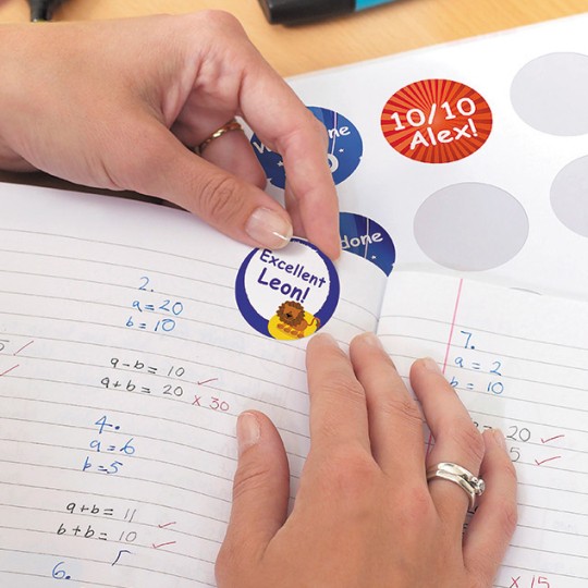 A teacher applying Avery printable merit stickers