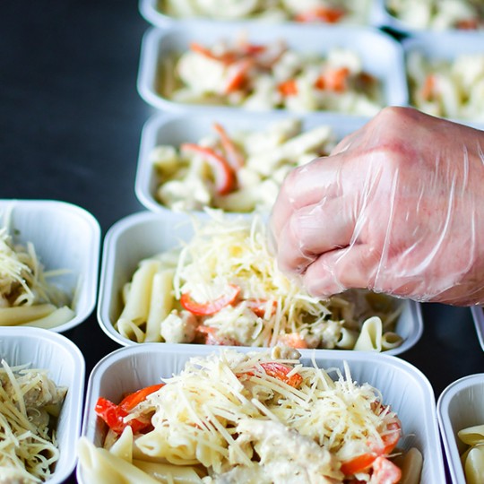 Image of a someone preparing food in some containers