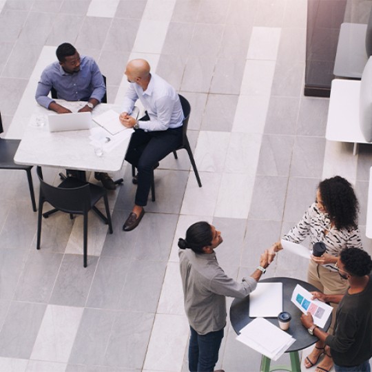 People sitting on tables conversing amongst each other at an event