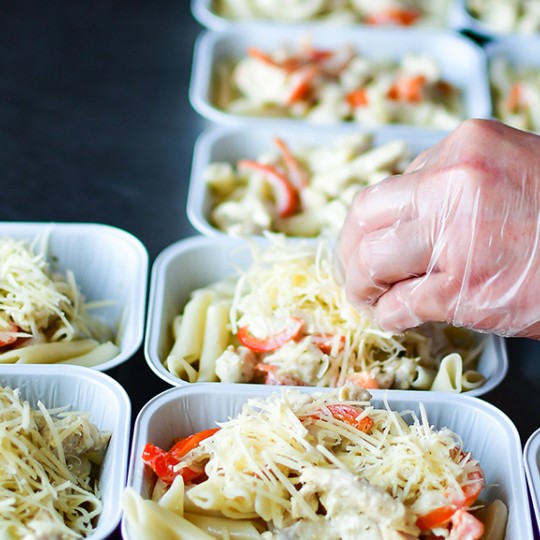 Image of a someone preparing food in some containers