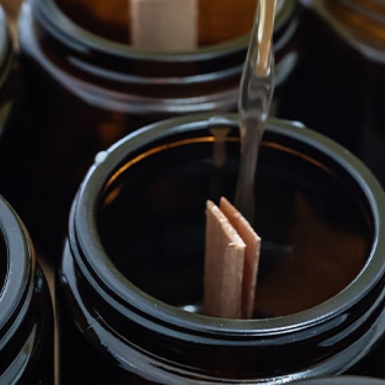 Header image of wax being poured into candle jars