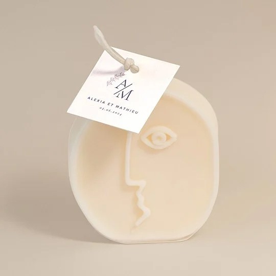 Candle tags square attached to a funky candle in the shape of an abstract face