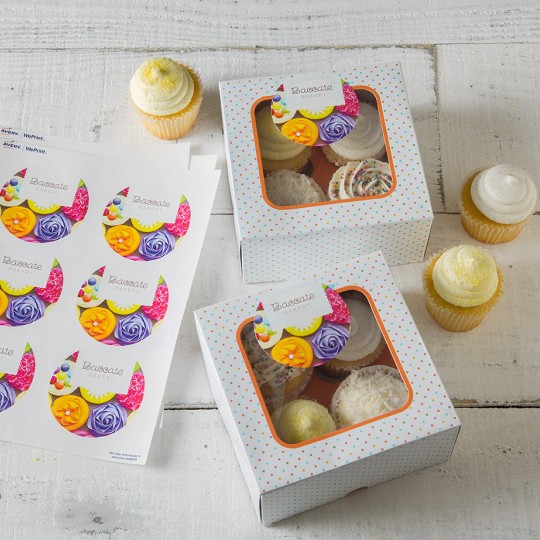 Labels in A4 sheets next to cupcakes in a box