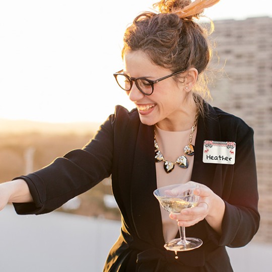 Happy woman with a glass of wine in a party with a fabric name badge with Chr
