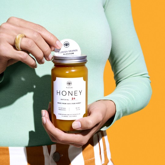 Round label on a honey label with woman holding on yellow background