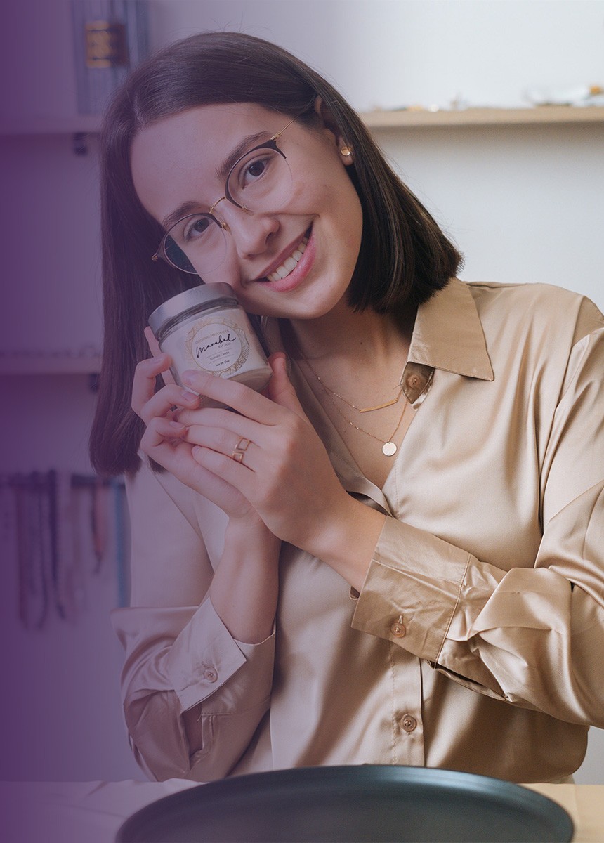 Professional-looking woman holding a candle as part of her candle-making business