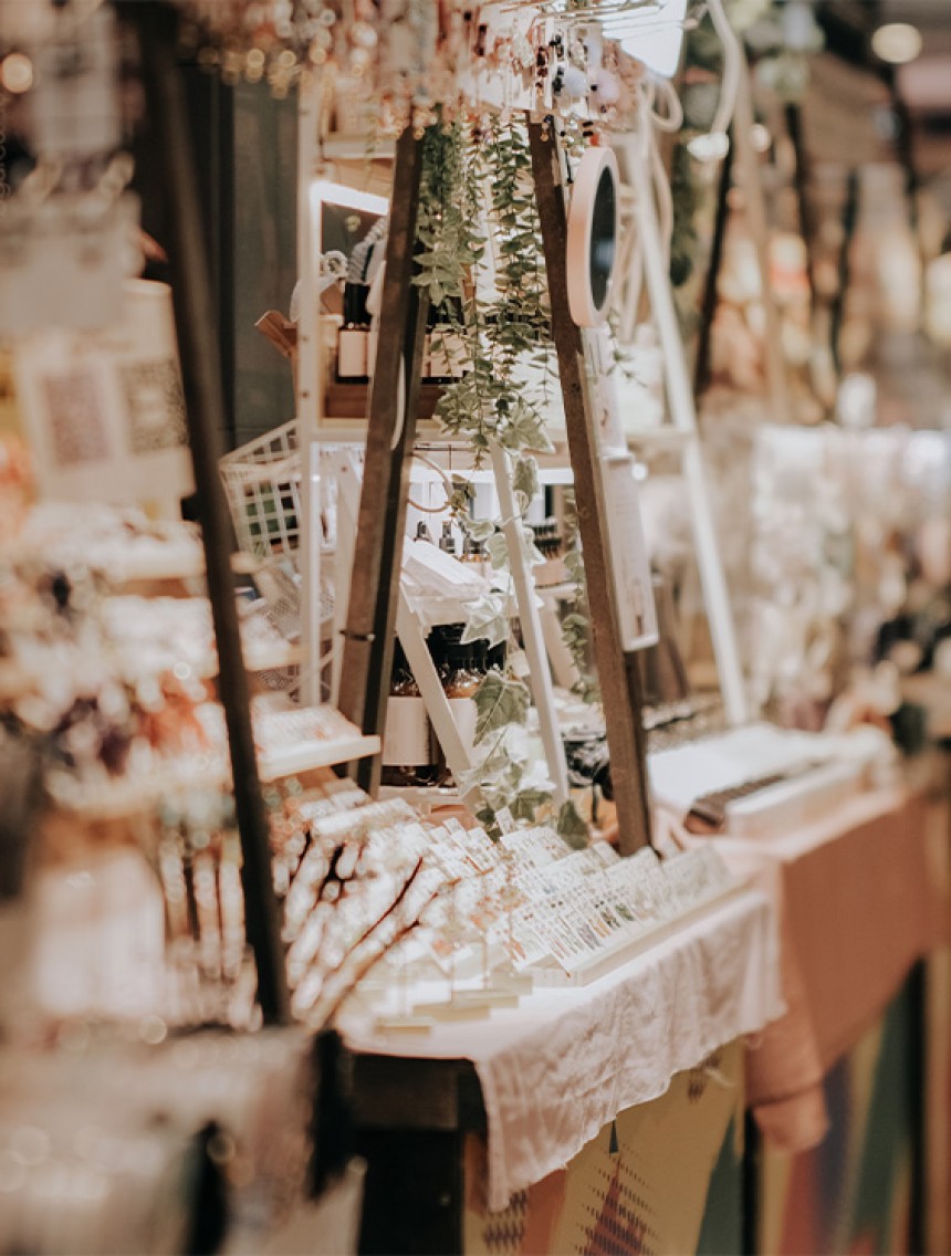 Shot of a stall at a market, with rows of jewllery and oils