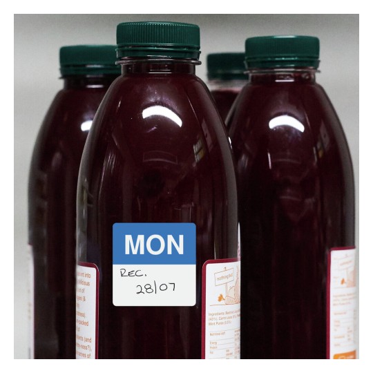 The image shows several bottles filled with a dark red liquid. One of the bottles has a label with the words 'MON', 'REC.', and a date '28/07'. The bottles appear to be juice or a similar beverage.