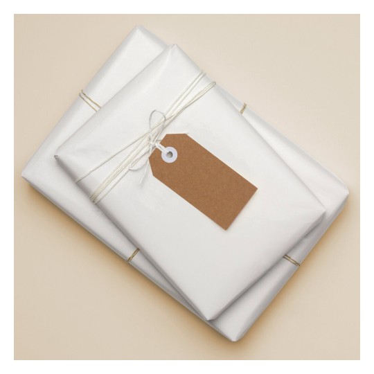The image features two neatly wrapped presents in white paper, tied with twine. One of the gifts has a brown tag attached, suggesting a personalized touch. The background is a soft beige, adding to the overall aesthetics of the presentation.