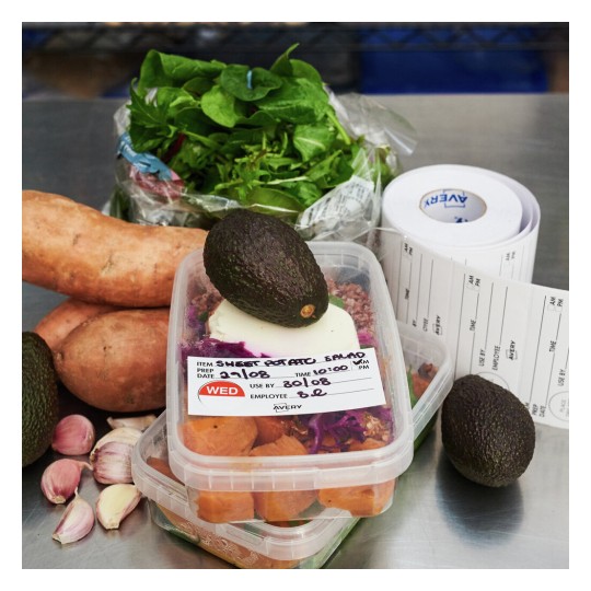 The image features ingredients for a sweet potato salad, including sweet potatoes, avocados, garlic, salad greens, and food containers with labels indicating preparation details.