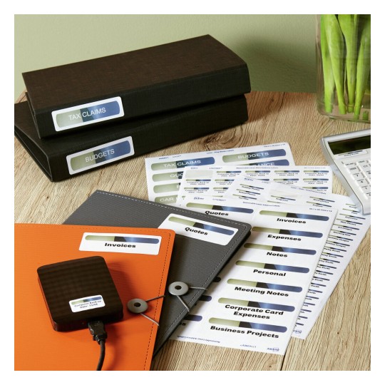 The image features various folders and labels related to financial documents such as tax claims, budgets, invoices, and quotes. A calculator is also visible, alongside neatly organized papers and a device, likely for digital storage.