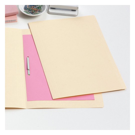 The image shows a beige folder with a pink sheet inside. There are also paper clips in a bowl and a stapler in the background, along with some stacked notepads.
