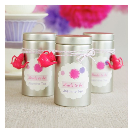 The image features three silver tea tins labeled 'Bride to be Jasmine Tea'. Each tin is decorated with a pink and purple design and adorned with a small pink watering can. The background has soft colors, enhancing a festive atmosphere.