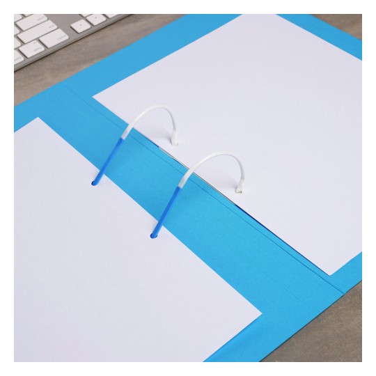 The image shows a blue binder with white sheets of paper inside. The binder's rings are visible, and a computer keyboard is partially seen in the background.