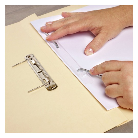 The image shows a person’s hands working with a binder clip on a stack of papers. One hand is securing paper with a clasp, while next to it, there's a metal binder clip positioned on a light-colored folder.