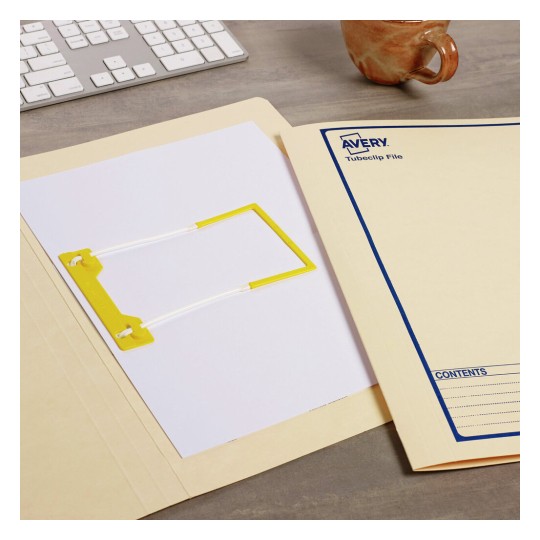 The image shows an office setup featuring a yellow tubiclip, a blank sheet of paper, and a beige folder labeled 'Avery Tubecip File'. A keyboard is partially visible in the background, along with a brown mug.