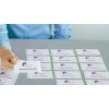 A person is placing a name badge for "Jessica Arnold" on a table with many other name badges, all featuring a purple "Gradin Investments" logo.