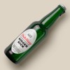 Green beer bottle laying on a white table with a white label on the bottle