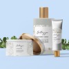 Blue background with 3 cosmetic items.  A tin, bottle and tube. All labeled with the same branding.