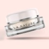 Clear label applied to a glass cosmetic jar on a pink background.