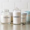 Custom printed clear labels applied to 4 different glass jars in a kitchen. The labels say Flour, Sugar and Baking Powder.