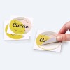 Round Sticker being peeled off backing sheet