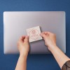 Square Sticker being stuck on a laptop