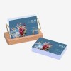 Stack of business cards for a wellbeing company on a white background. The design on the business card is blue background with floral illustration in the corner