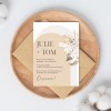 Wedding invitation in earthy natural light brown colour with cream flowers on the side.