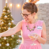 Picture of a woman in a pink dress at a christmas party with a christmas name badge