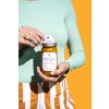Round label on a honey label with woman holding on yellow background