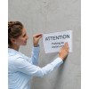 Women putting a sign on a concrete wall