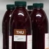 The image features several bottles of reddish juice, each with a green cap. One of the bottles has a label indicating a day of the week (THU) and a date (28/07) along with some ingredient information on the side.