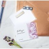 The image features a pink and white marbled card labeled 'Bellezza Everyday Beauty' by Kathy Macneil, alongside a bronze envelope, a pen, and some berries on a light stone surface.