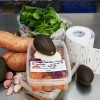 The image features ingredients for a sweet potato salad, including sweet potatoes, avocados, garlic, salad greens, and food containers with labels indicating preparation details.