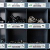 The image shows a storage unit with labeled compartments containing various hardware items such as washers, pipe fittings, and screws. Each section is clearly marked with names and sizes.