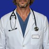 The image features a person wearing a white lab coat over a blue scrub top, with a stethoscope draped around their neck. A name tag is visible on the coat, indicating 'Brett Whiteley'. The background is a solid blue color.