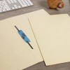 The image shows a workspace with a light-colored file folder, a piece of blue tape, and a keyboard in the background. A mug is also visible on the table.