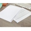 An image of a workspace featuring a folder with blank sheets, a checklist page, a keyboard, and a ceramic mug.