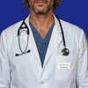 The image features a person in a white lab coat with a stethoscope around their neck, set against a blue background. The lab coat has a name tag labeled 'Brett Whiteley'.