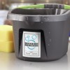 The image shows a gray cleaning bucket with a label indicating cleaning services, along with a yellow sponge beside it. The bucket has water droplets on it, suggesting it's recently been used.