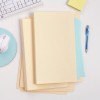 The image features a set of colored folders stacked on a desk. There is a computer keyboard, a mouse, and a pen nearby, along with a small pad of sticky notes. The background is minimalistic.