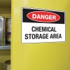 The image shows a bright yellow cabinet door with a sign that reads 'DANGER CHEMICAL STORAGE AREA'. This indicates a hazardous area where chemicals are stored, suggesting caution is needed when approaching.